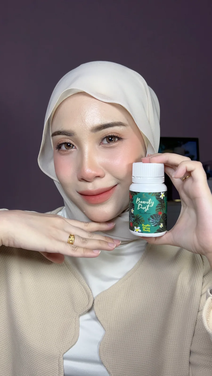 Pengguna memegang botol Cleopatra Beauty Dust